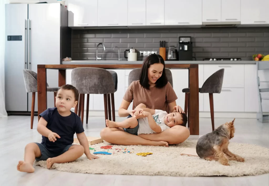 Happy family sitting on kitchen floor with dog